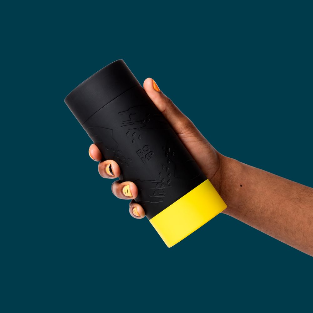 Product display showcasing Romp Dash Manuel Stroker by Wow Tech. Stroker is black with yellow base in a cylinder shape held in hand. 