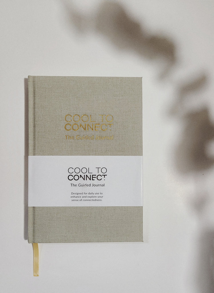 Canvas material Journal displayed on solid white background with plant shadow. Product is a connection inspired prompted journal by Cool to connect