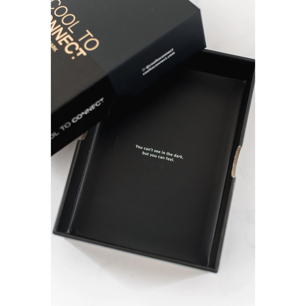 Opened box of cool to connect after dark edition laid on white surface. Displays bottom of conversation deck box with text and top of box slightly offset in left corner. 
