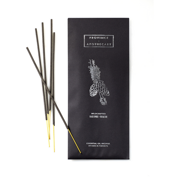 Black and foil decorated paper wrapped package of Province Apothecary Essential oils Incense sticks with 5 essential oil incenses placed in front on a white background. 