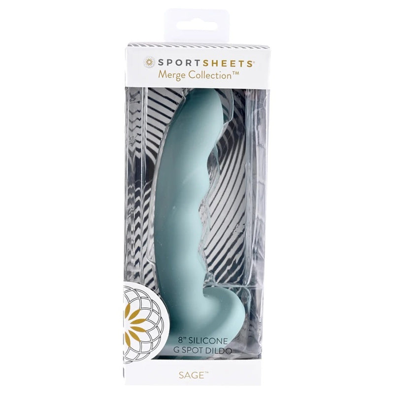 Sage blue silicon dildo sexual wellness and pleasure product being displayed on solid white background. Product is laying in Sportssheets product packaging featuring a suction cup base. 