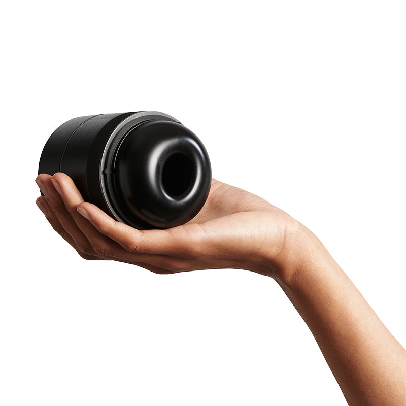 Image shows pale hand holding the Arc Wave compact stoker flat in hand to display product on solid white background. 