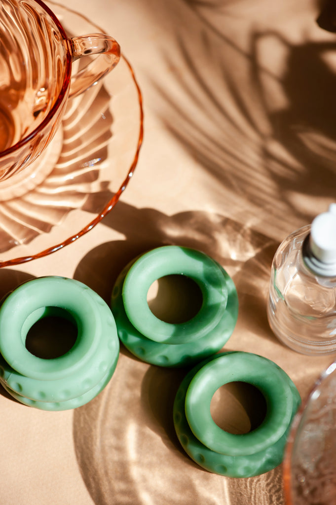 OhNut sexual wellness buffer rings being displayed on a bedside table individually placed beside one another. 