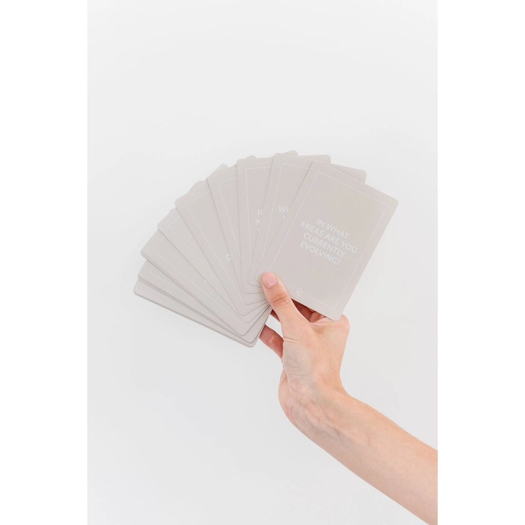 Cool to connect deck cards being held and displayed in a hand on a solid white background. 